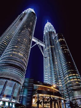 Stunning nighttime view of the illuminated Petronas Towers in Kuala Lumpur, Malaysia.